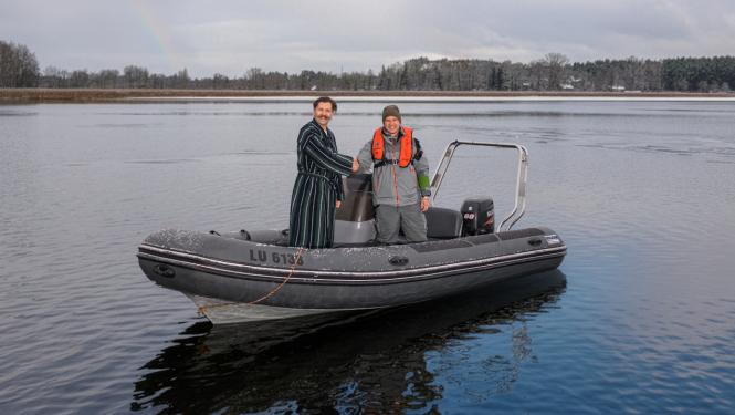 2 cilvēki uz ezera laivā sarokojas