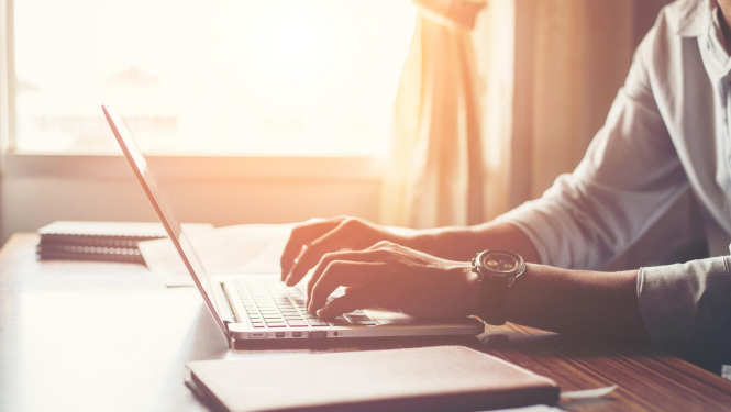 Attēlā redzams vīrietis, kas strādā pie datora