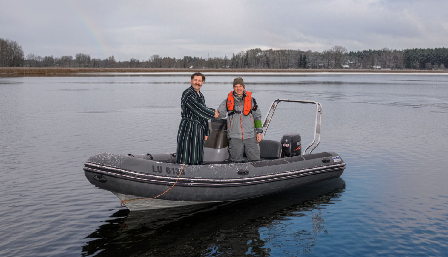2 cilvēki uz ezera laivā sarokojas