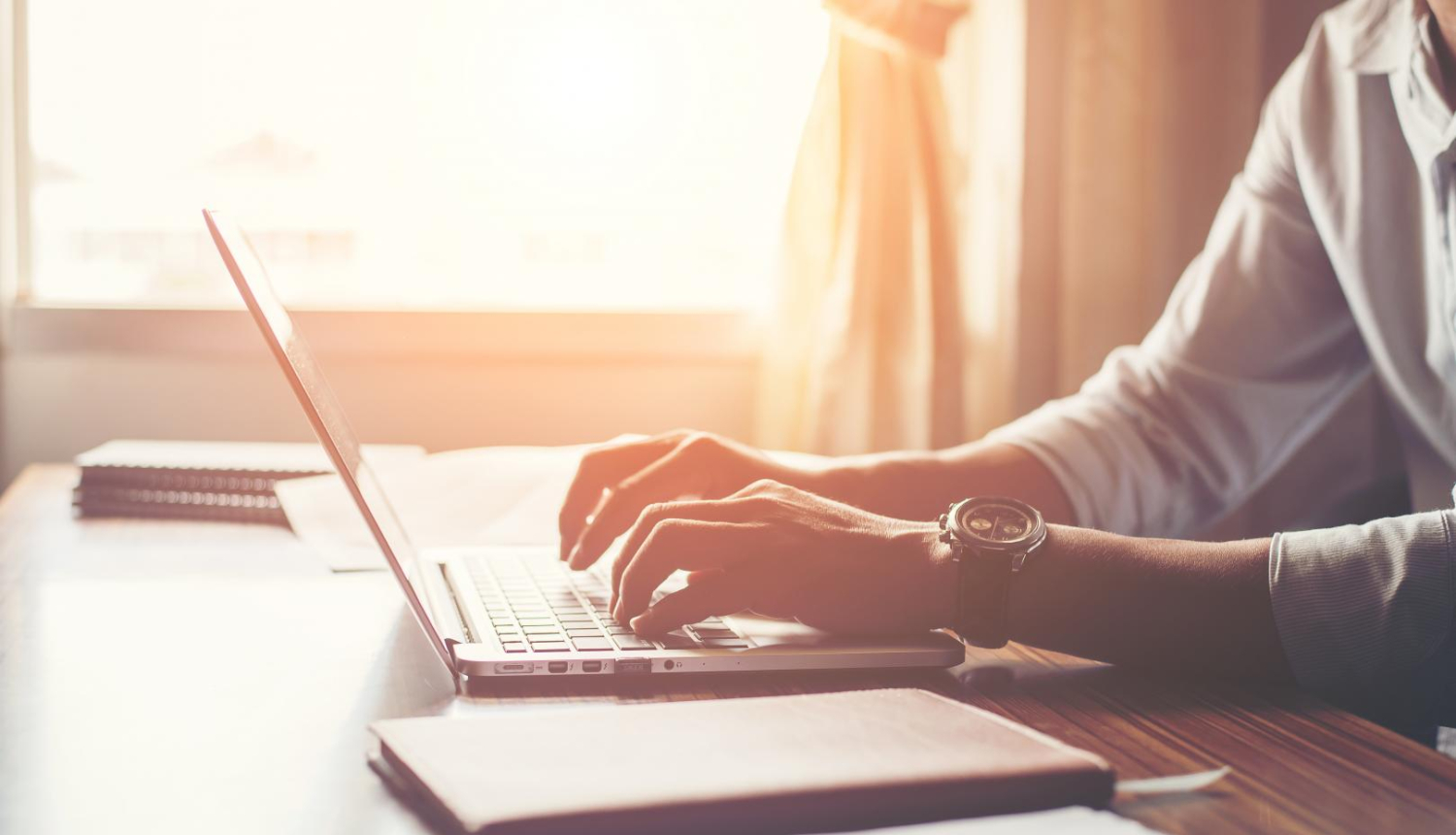 Attēlā redzams vīrietis, kas strādā pie datora